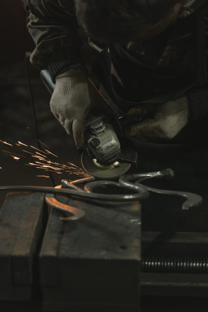 Close-up of angle grinder in use, creating sparks during metalwork indoors.